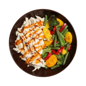 Caribbean Mango Medley with chopped chicken, mango habanero sauce, green beans, broccoli, red peppers, and yellow carrots in a brown bowl