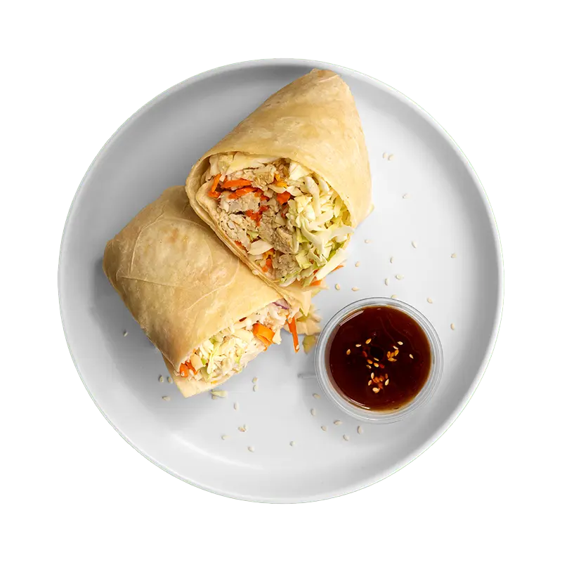 Teriyaki Crunch Wrap with chicken, cabbage, carrots, sesame seeds, and sweet teriyaki sauce on a white plate